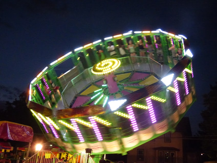 Riders defying gravity on spinning amusement park ride